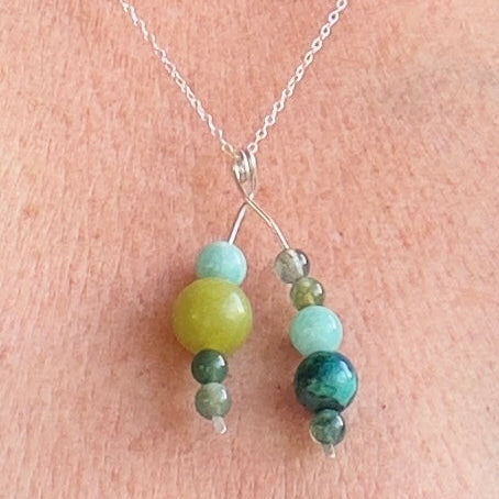 Necklace with green and blue beads on a person's neck