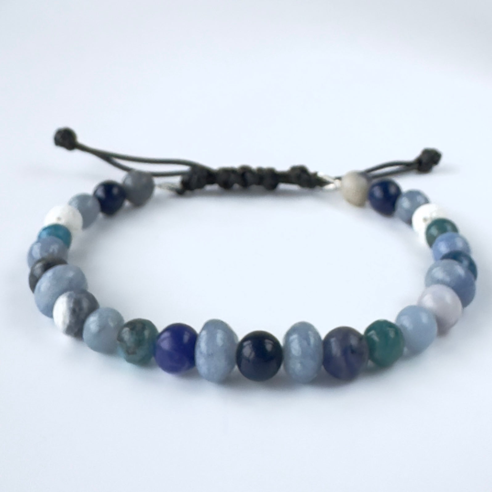 Beaded bracelet in shades of blue and white stones on a white background