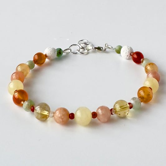 Multicolored beaded bracelet in tones of yellow and orange on a white background