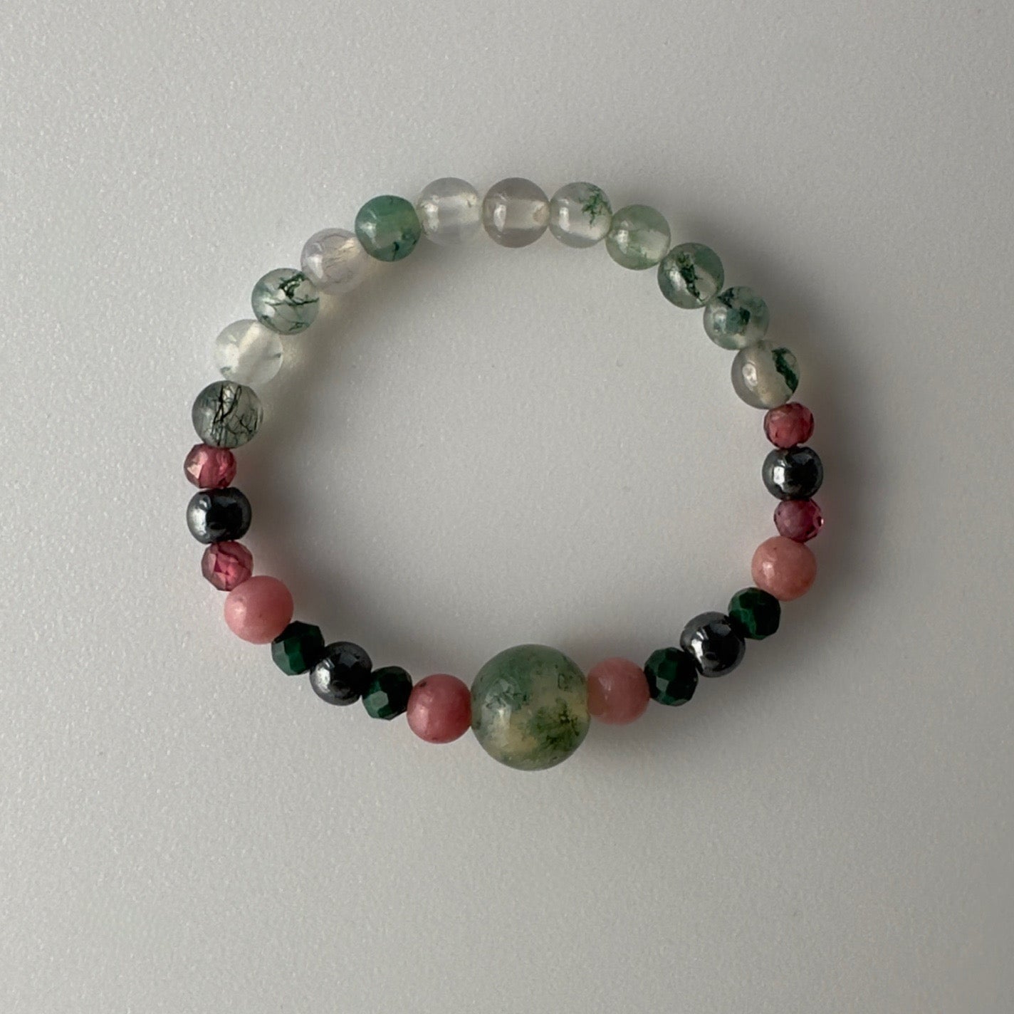 Multicolored beaded ring on a light grey background