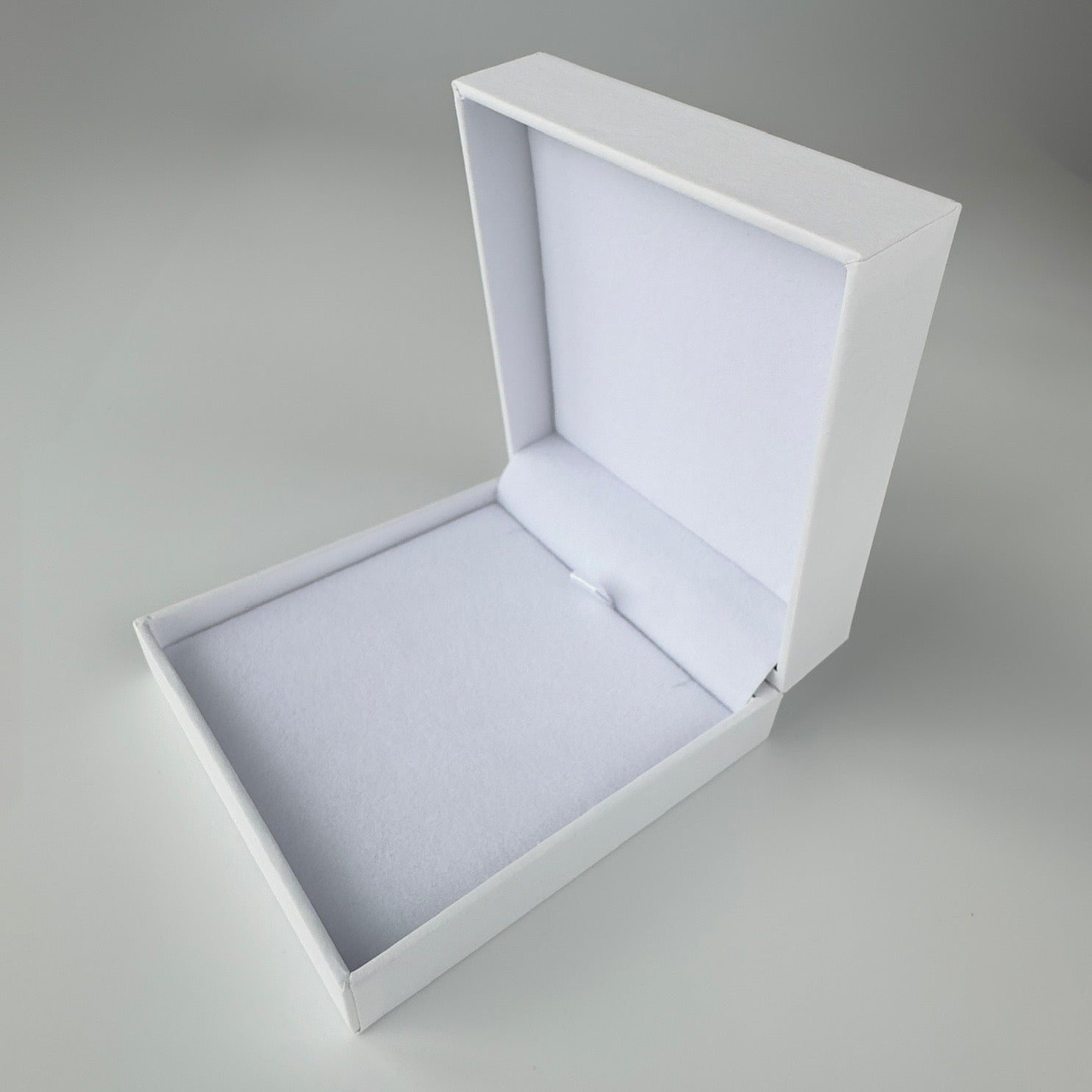 White jewelry box with a gray interior on a light gray background