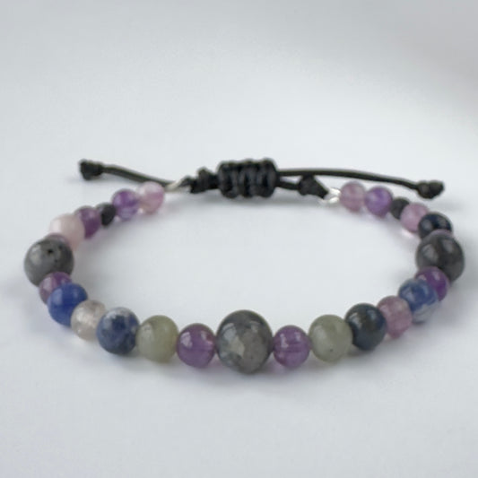Grey and purple beaded bracelet on a white background