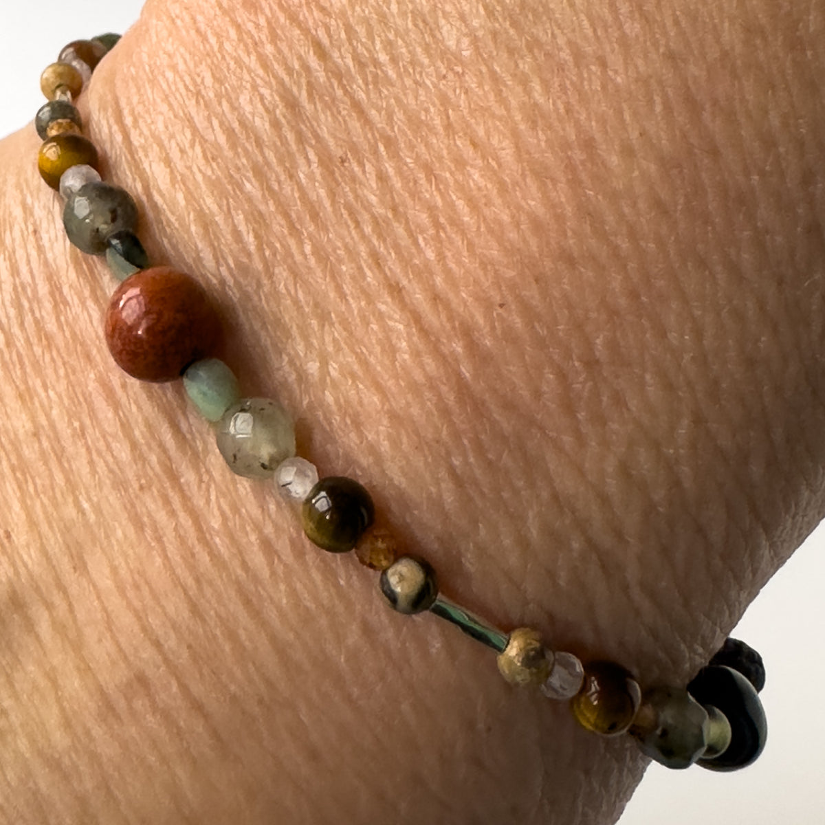Leo Healing Crystal bracelet for Stress on wrist showing Yellow Tiger’s Eye, Jasper, Garnet, Bloodstone, Emerald and Clear Quartz