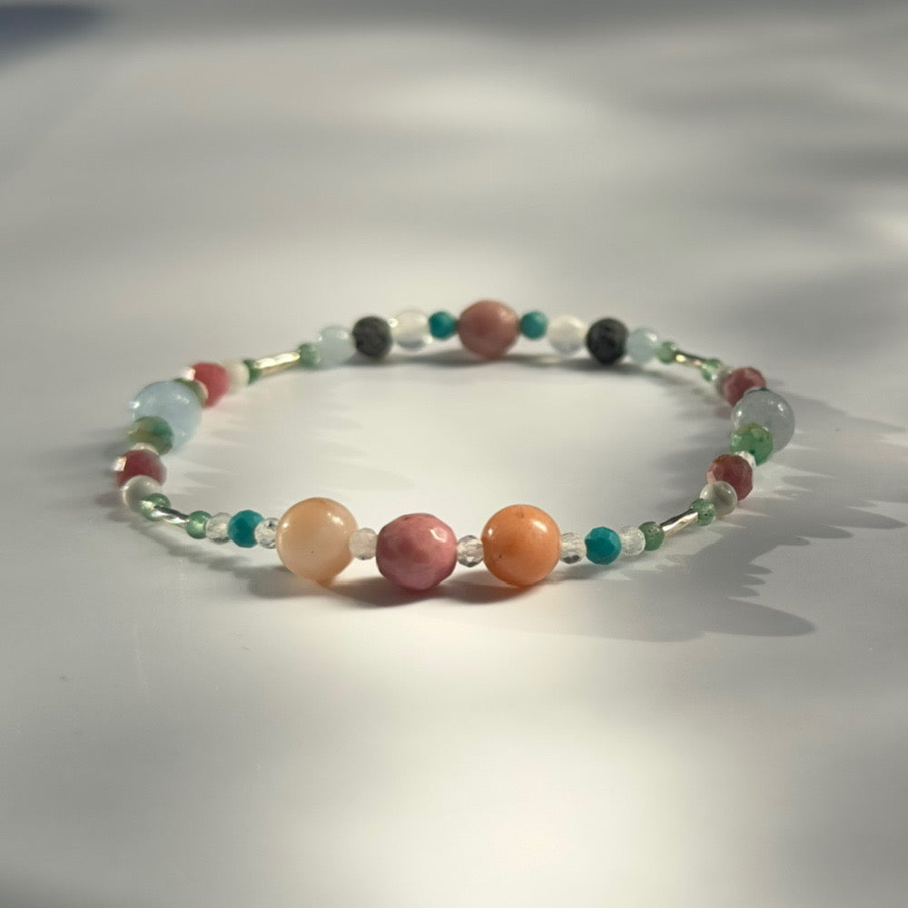 Beaded bracelet with multicolored beads on a light gray background