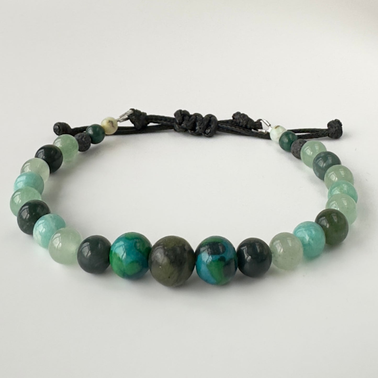 Bracelet with green and black beaded design on a white background