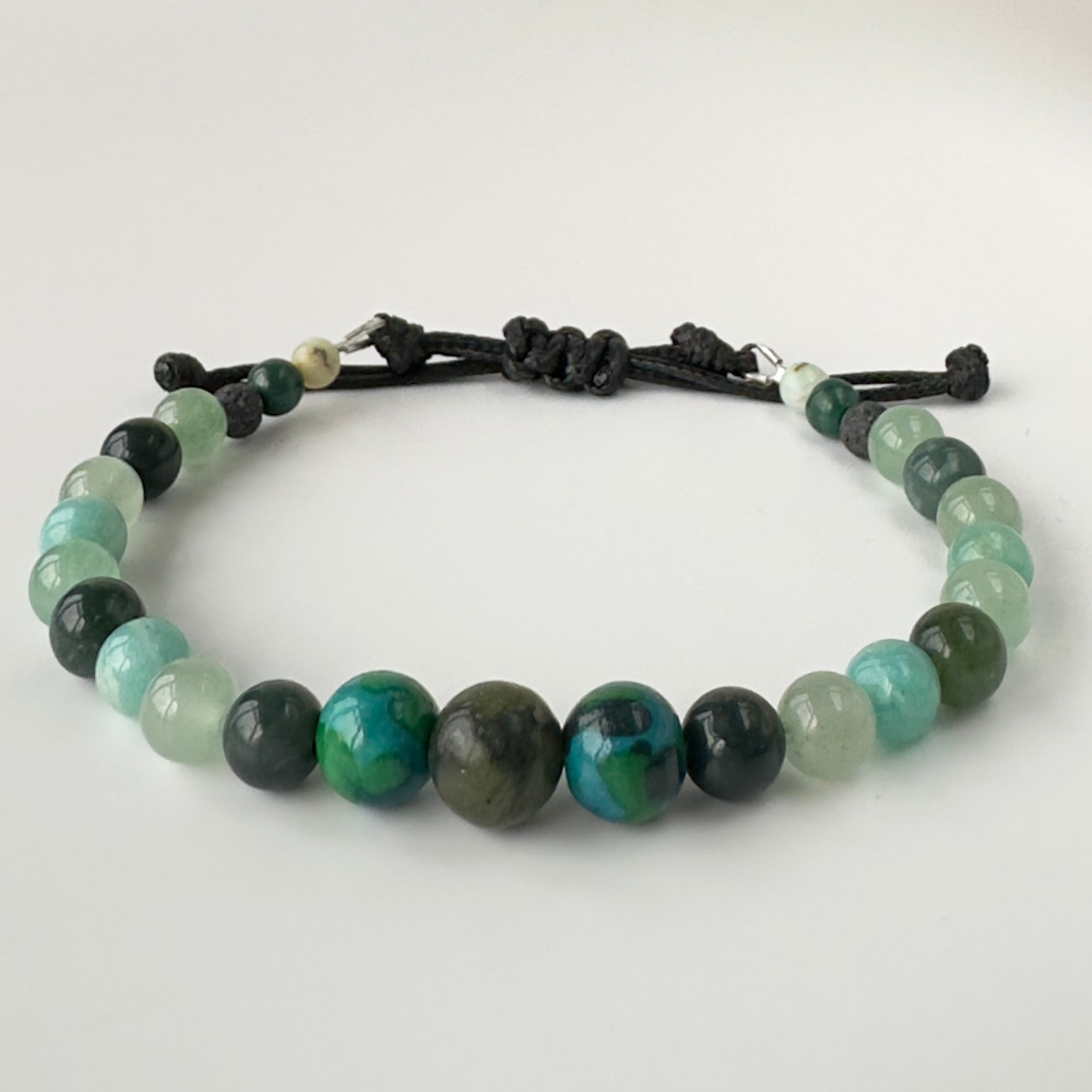 Bracelet with green and black beaded design on a white background