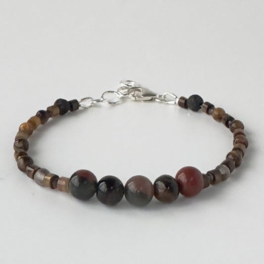 Beaded bracelet in brown tones on a light grey background