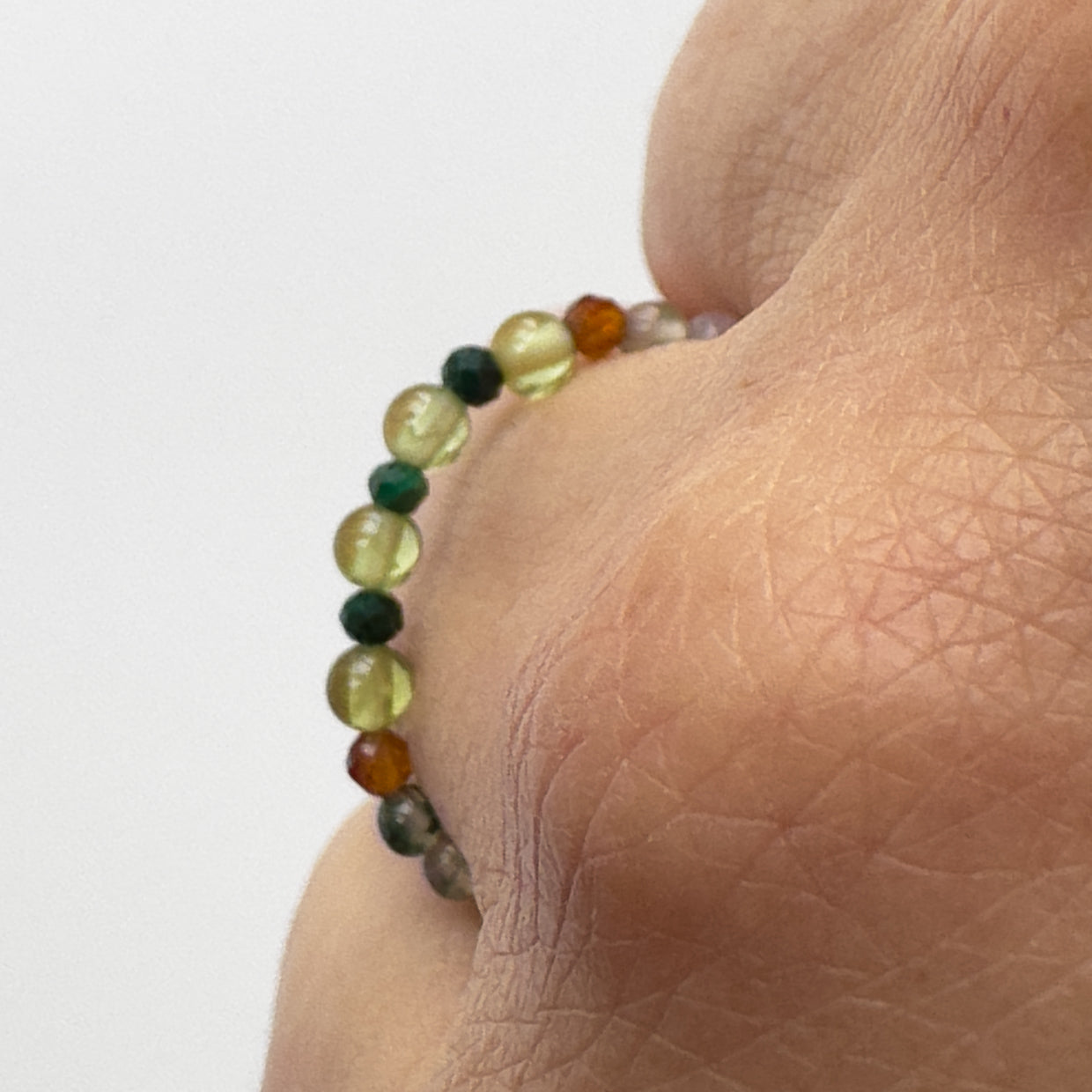 Profile view of green and brown beaded ring