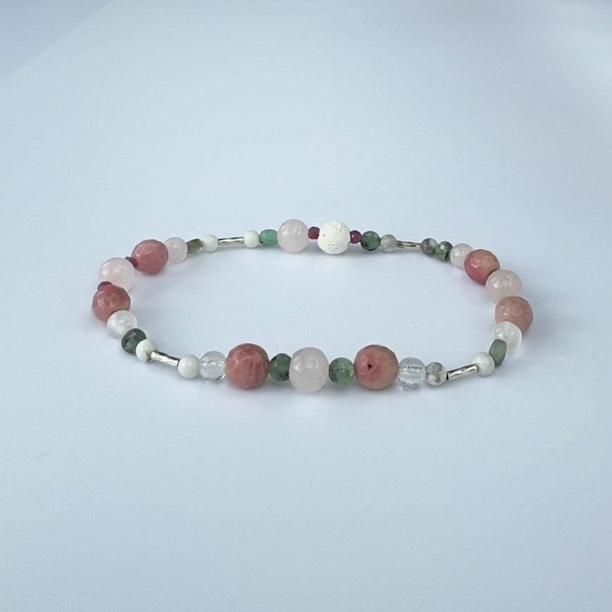 Beaded bracelet in pink green and white tones on a pale grey background
