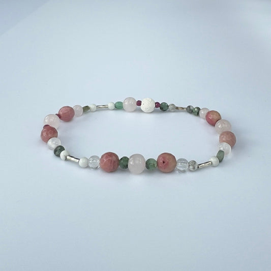 Beaded bracelet in pink green and white tones on a pale grey background
